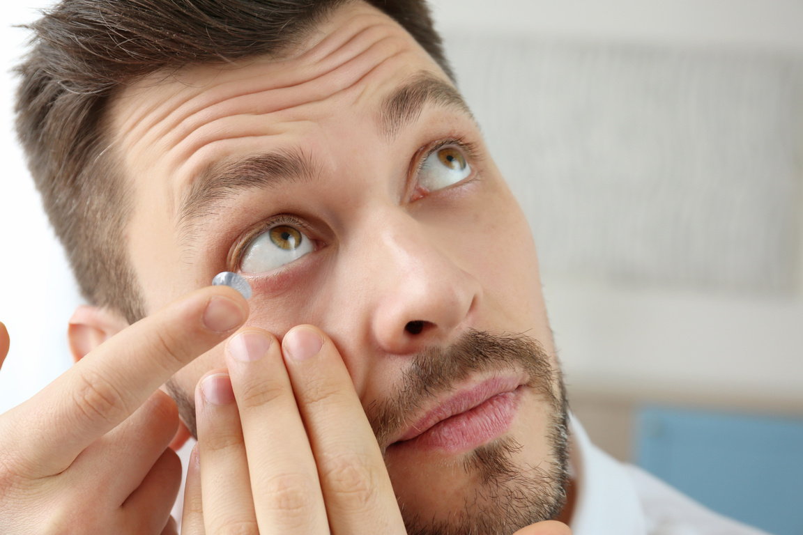 Young Man Putting Contact Lenses at Home